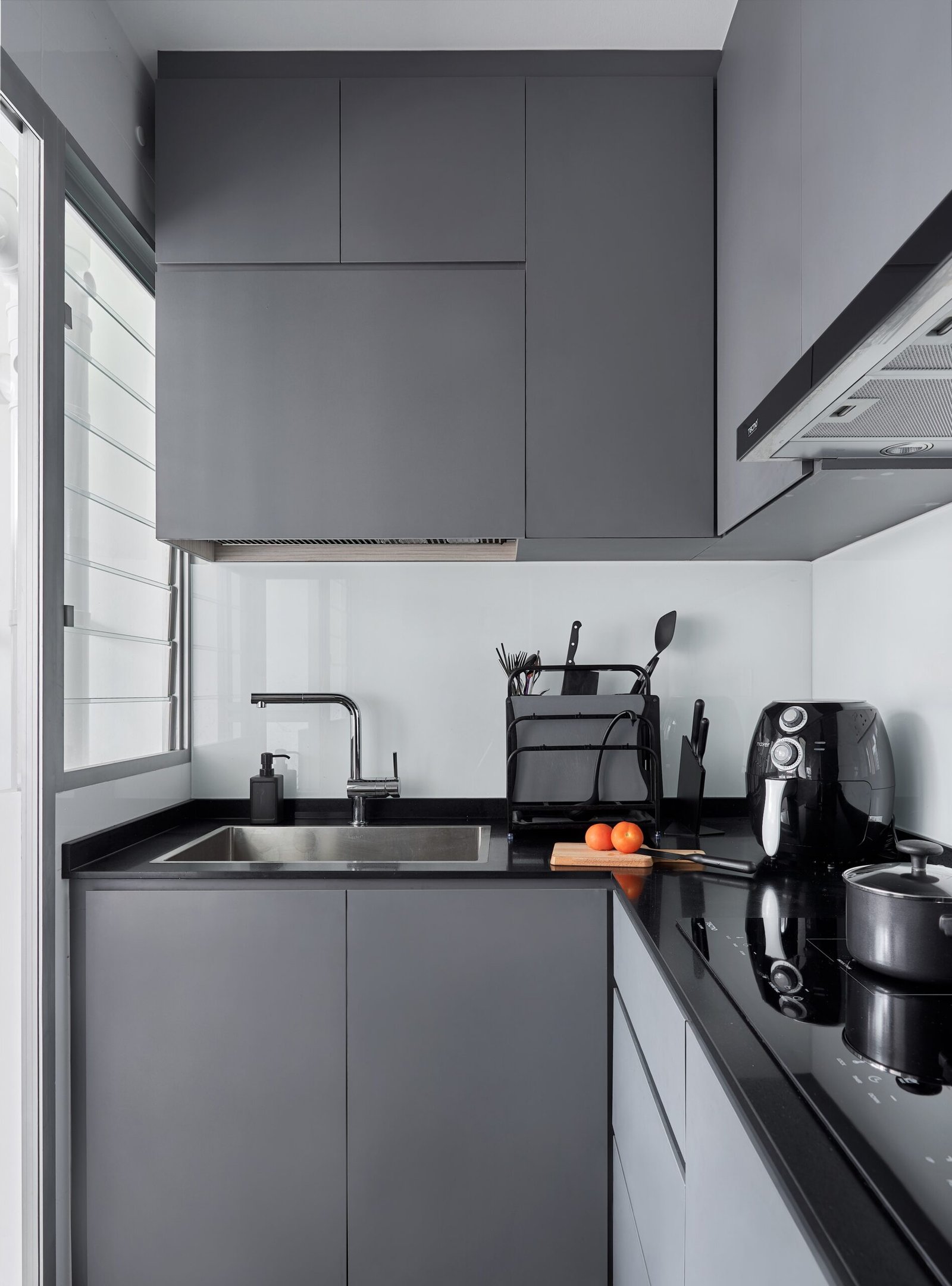 Anchorvale Lane kitchen with grey cabinetry, dark worktop and integrated appliances